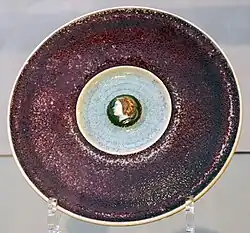 Violett und hellblau glasierter Teller mit Kopfmedaillon