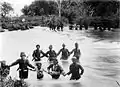 Niederländische Kolonialsoldaten und indonesische Zivilisten überqueren den Samalanga-Flusses in Aceh während der Militärexpedition unter J. B. van Heutsz.