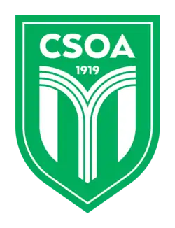 Schriftzug zweizeilig CSOA 1919 nebst einer darunter befindlicher Grafik auf grünem und quadratischen und unten leicht oval zulaufenden Grund.