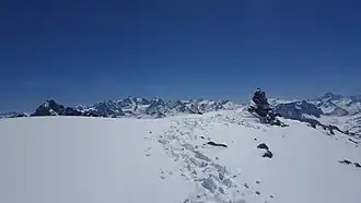 Steinmann auf dem Piz d’Agnel, im Hintergrund Piz Julier, die Berninagruppe und Monte Disgrazia.