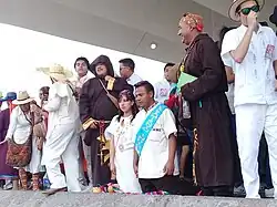 Weiss gekleidete Karnevalsteilnehmer stellen eine Hochzeitsszene nach