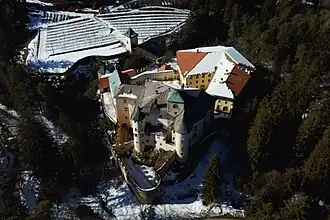 Luftaufnahme mit der Ostseite im Vordergrund; rechts im Hintergrund die Wirtschaftsgebäude