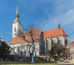 Das Bild zeigt eine weiße Kirche mit rotem Dach unter freiem Himmel.