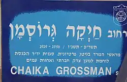 Blaues Straßenschild mit Grossmans Namen und Beschriftung, die auf ihre Verdienste hinweist (in Hebräisch)