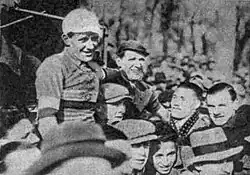 Das Schwarz-Weiß-Foto zeigt eine Menschenmenge, die sich am 3. Februar 1935 nach dem 11. Critérium International de cyclo-cross pédestre in Suresnes bei Paris gebildet hat. Charles Vaast ist die hintere Person, oben Mitte, neben ihm steht der Gewinner Josy Mersch