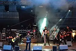 Chencha Berrinches beim Wilwarin Festival 2014, eine siebenköpfige Band, angestrahlt von einem grünlich-weißen Bühnenscheinwerfer