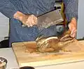 Zerteilen eines gegarten Hähnchens (einschl. des Knochengerüsts) mit einem Hackmesser
