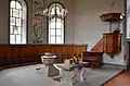Chor mit neugotischem Taufstein, Abendmahls­tisch und barocker Kanzel