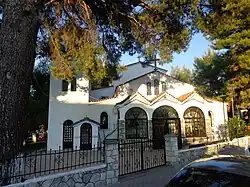 Kircheneingang der Kirche Agios Chrysostomos, Chaniotis. Dreibogiger Eingang unter einer großen Kiefer