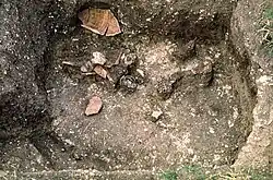 Zerbrochene Urne und Grabbeigaben