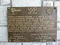 Tafel am Stadio Olimpico del Ghiaccio in Erinnerung an die Olympischen Winterspiele 1956