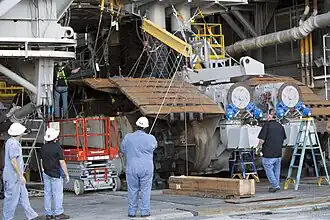 Demontage der Kette für die Wartung des Getriebes. Zwischen den beiden Kettenlaufwerken sind zwei Antriebsmotoren mit Bremsscheiben angebracht.