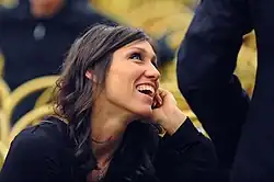 Cristina Chiuso trägt dunkle Kleidung und befindet sich in einem Saal mit goldfarbenen Stühlen.