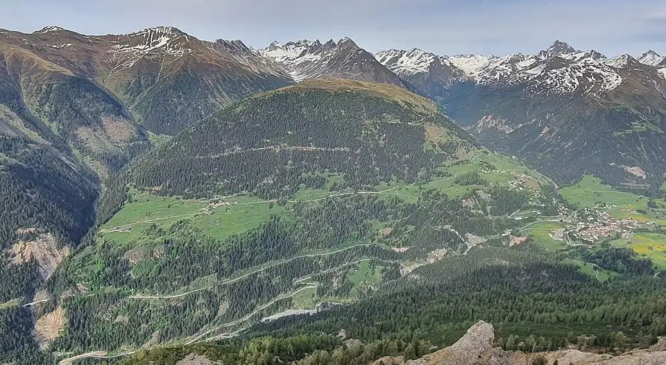 Blick nach Osten zum Cuolm da Latsch (2295&nbsp;m), ein Rasenhügel an dessen Westhang die Dörfer Stugl/Stuls (links) und Latsch liegen, am rechten Bildrand ist Bergün/Bravuogn zu sehen