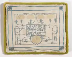 Kissenbezug mit Inschrift We are such things as dreams are made of (1900).