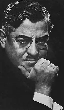 Schwarz-weiß-Portrait von Demetrius Constantinous Dounis, mit in die Hand aufgestütztem Kinn, kräftigem, aber nicht sehr breiten Schnauzbart und runder, wenig auffallender, bügelloser Brille (Kneifer), in einer Aufnahme von 1940