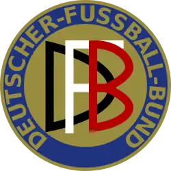Abgebildet ist das Logo des Deutschen Fußball-Bundes von 1900 – 1945. Es stellt einen Freis dar, der in blau und gold gehalten ist. Am äußeren Rand wird der Schriftzug DEUTSCHER-FUSSBALL-BUND im Kreis geführt. In der Mitte befindet sich die Abkürzung "DFB": Jeder Buchstabe in einer anderen Farbe, weiß schwarz und rot.