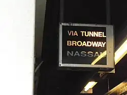 Zugzielanzeiger als Leuchtkasten mit dreizeiliger Beschriftung „Via Tunnel / Broadway / Nassau“