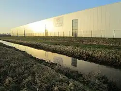 Lagerhalle der Kunststoff-Firma RPC Bramlage (heute Berry Bramlage genannt) westlich der Fischteiche des Fischereivereins Dinklage (vor der Renaturierung des Baches).
