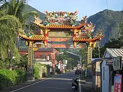 Eingangstor zum Dorf Dulan, im Hintergrund das Haian-Gebirge