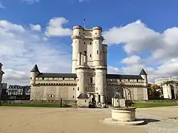 In Teilen des Schlosses von Vincennes, dessen helle Gebäude mit Türmen und Verlies vor blauem Himmel mit weißen Wolken zu sehen sind, befindet sich ein Teil des französischen SHD