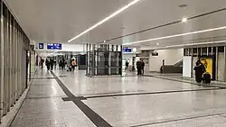 Der verbreiterte Fußgängertunnel des Dortmunder Hauptbahnhofs im März 2024 kurz vor Abschluss der Renovierungsarbeiten mit neuem Fußbodenbelag, neuer Decke und neuer Wandverkleidung in deutlich hellerer Farbgebung (vorher rötlich-brauner Fußboden, gelbliche und weiße Wandfliesen sowie eine lichtgraue Decke).