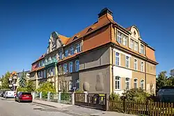 Fotografie eines dreigeschossigen großen Altbaus mit Walmdach