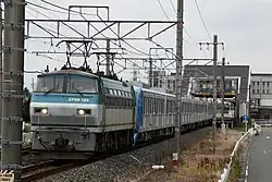Zug der Baureihe 15000 für die Tōzai Line der Tōkyō Metro auf Überführungsfahrt im Eisenbahnnetz, gezogen von einer Lokomotive der Baureihe EF66-100