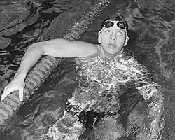 Auf diesem Schwarzweißfoto stützt sich Schlingemann nach der Zielankunft auf der Trennleine ab. Er hat seine Schwimmbrille nach oben geschoben.