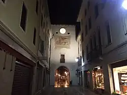 Ein Durchgang durch einen Turm mit einem Markuslöwen im Zentrum von Spilimbergo bei Nacht.