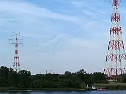 Ein Containerschiff (nur die Mastspitzen erkennbar) unterquert die Elbekreuzung 2