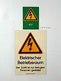 Veraltete Kennzeichnung mit Warnzeichen nach DIN 4844-2, zusätzlich Kennzeichnung Notstrom