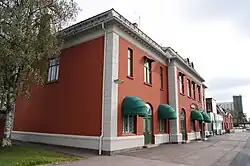 Foto eines rötlich gestrichenen Bahnhofsgebäudes