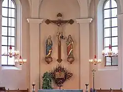 Kreuzigungsgruppe an der Ostwand 2005 (links) und 2016 (rechts): Das Kreuz wurde im Zuge der Renovierung an die schlichte Einrichtung angepasst und besteht jetzt nur noch aus einfachen rechteckigen Hölzern.