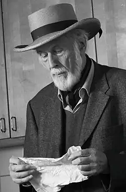 Erich Ess in der Galerie Neunzendorf, 2015, zu sehen ist Erich Ess im hohen Alter, stehend mit einem Hut auf