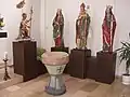 Taufstein und Heiligenfiguren