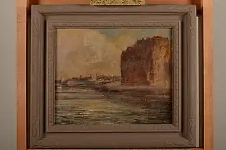 Gemälde im Holzrahmen mit einer Küstenansicht. Blick vom Wasser auf eine hohe Klippe im Vordergrund rechts, dahinter die Umrisse einer Hafenstadt.