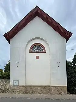 Ehemaliger Eingang mit Erinnerungstafel an den Kirchbau