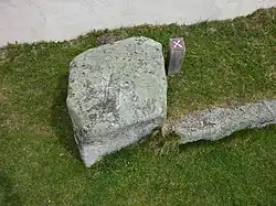 Kreuzstein vor der Kirchenmauer