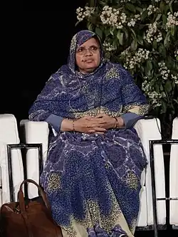 Fatimetou Abdel Malick beim Foro Mundial sobre las Violencias Urbanas, Madrid 2017. Eine sitzende nordafrikanische Frau mit Kopftuch. Kopftuch und Kleid sind passend zueinander gepunktet.