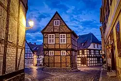 Fachwerkhäuser am Finkenherd in Quedlinburg bei Abenddämmerung mit beleuchteter Straßenlaterne