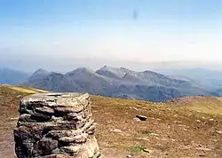 Der trigonometrische Punkt auf dem Gipfel des Slioch, im Hintergrund die Berge des Fisherfield Forest im Norden