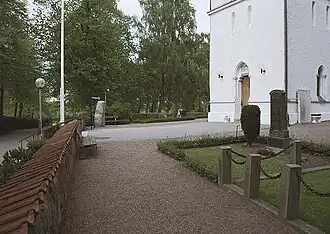 Fosiestein (links) vor der Kirche