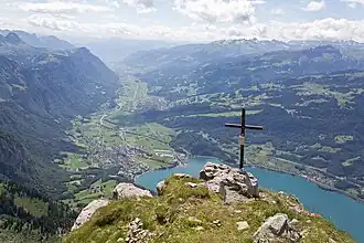 Das Gipfelkreuz des Frümsel, Blick südostwärts auf Walenstadt und das Seeztal
