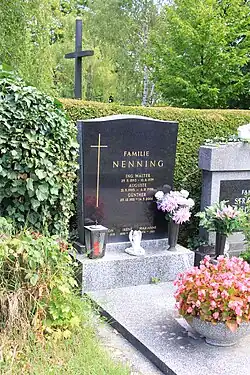 Grabstein mit prominenter Gravur dreier dort beerdigten Personen und weiterer Familienmitglieder am unteren Rand in Farbe.