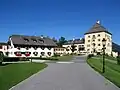 Auffahrt, Blick auf den historischen Schlossturm mit einem Teil der Nebengebäude und dem Jägerhaus mit Schloss Ladl.