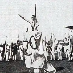 Der französische Sportler Géo André schwört bei den Olympischen Sommerspielen 1924 den Olympischen Eid und entbietet dabei die Geste des Olympischen Grußes.