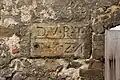 In den ehemaligen Türsturz eingehauene Inschrift
