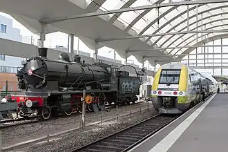 Denkmallokomotive und Regionalzug in der Bahnhofshalle