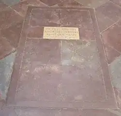 In den Boden eingelassener Stein mit einer Tafel nebst Inschrift der Sterbedaten.